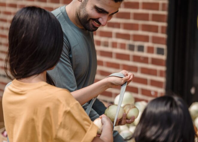 Man putting onions in bag with children